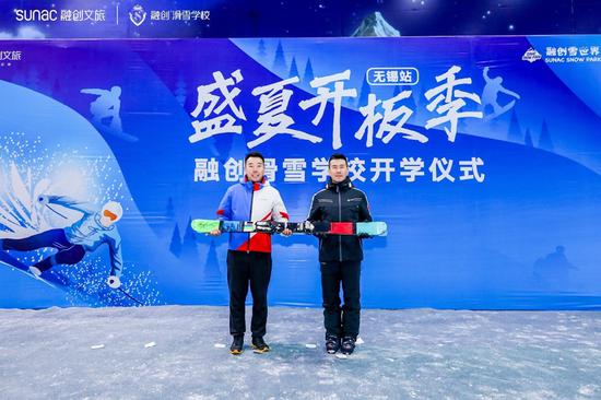 图片：奥运冠军韩晓鹏向融创滑雪学校校长伊力赠送礼物