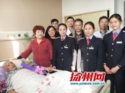 老夫妇与伸手相帮的乘务人员、医护人员合影。
