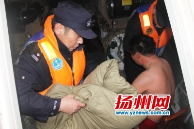 救援人员给坠江男子拿来棉被取暖。