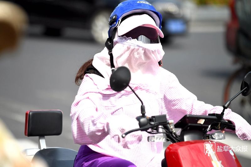 8月3日,市民"全副武装"做好防晒工作出门.